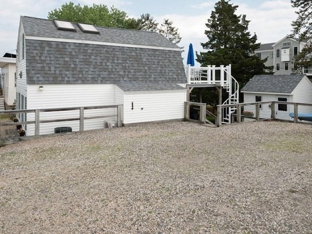 5 I St Unit 2, Newburyport, MA 01950 - rear view of house with stairway, roof with shingles, a storage shed, and a gambrel roof
