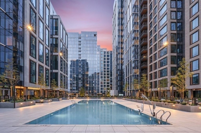 pool at dusk with a patio