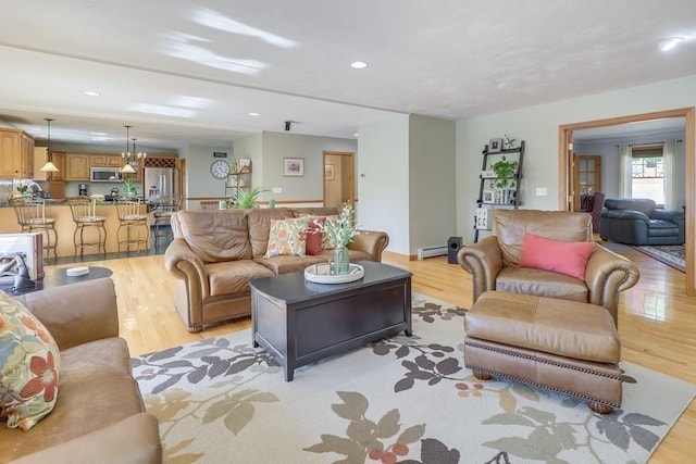 living room featuring a baseboard heating unit and light hardwood / wood-style floors