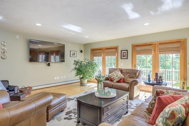 living room with a baseboard heating unit and light wood-type flooring