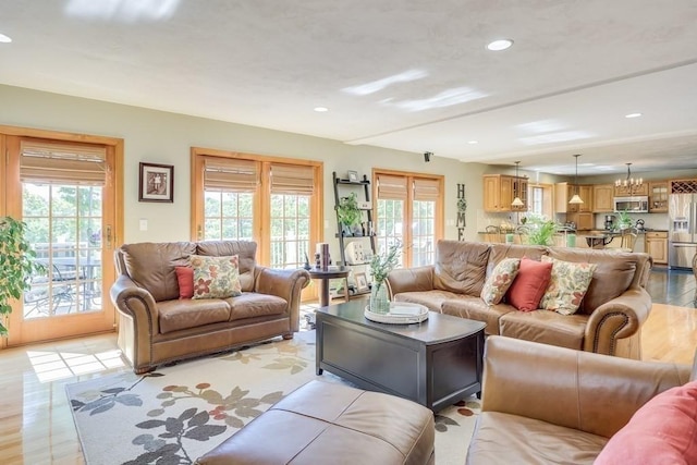 living room featuring an inviting chandelier and light hardwood / wood-style floors