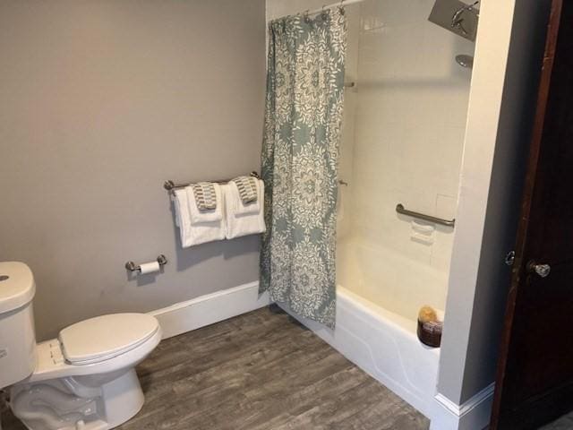 bathroom featuring wood-type flooring, toilet, and shower / bathtub combination with curtain