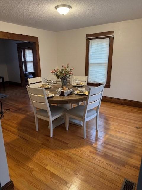 dining space featuring hardwood / wood-style flooring and a textured ceiling