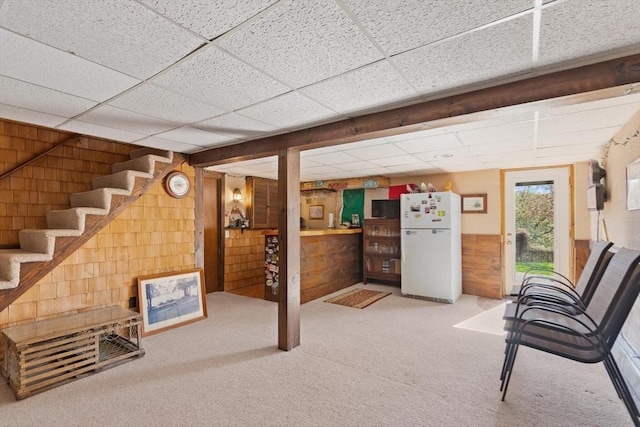 24 Hodgkins Dr, Ipswich, MA 01938 - below grade area with a paneled ceiling, wood walls, carpet floors, freestanding refrigerator, and stairs