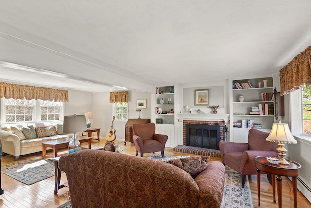 24 Hodgkins Dr, Ipswich, MA 01938 - living area featuring a healthy amount of sunlight, a brick fireplace, and wood finished floors