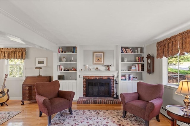 24 Hodgkins Dr, Ipswich, MA 01938 - living area featuring crown molding, a brick fireplace, built in shelves, baseboards, and light wood finished floors