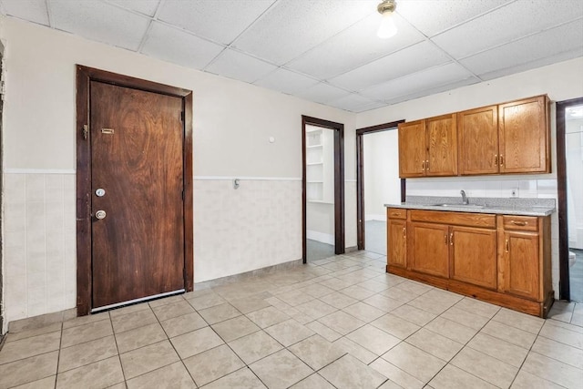 kitchen with sink, light tile patterned floors, and a drop ceiling