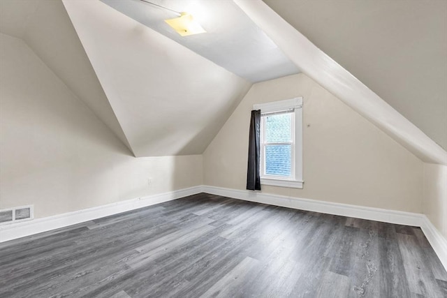 bonus room with vaulted ceiling and dark wood-type flooring