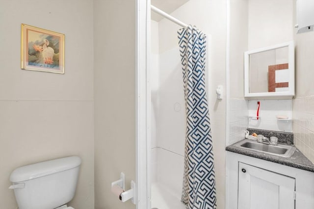 bathroom featuring tasteful backsplash, vanity, a shower with shower curtain, and toilet