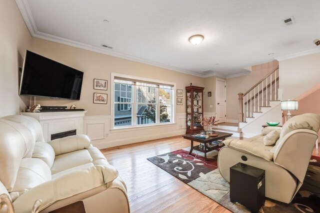 living room featuring ornamental molding and light wood-type flooring