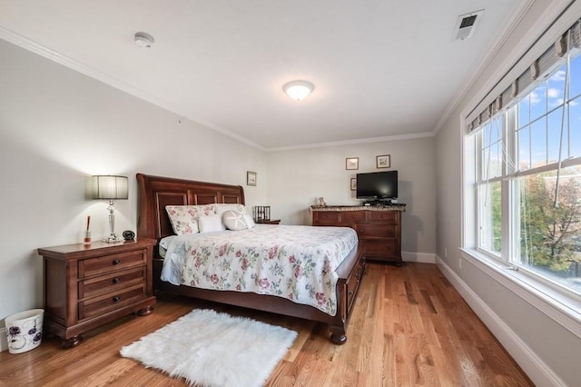 bedroom with light wood-type flooring, multiple windows, and crown molding