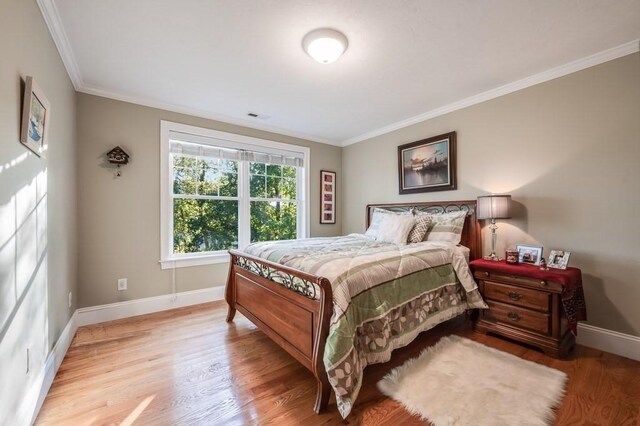 bedroom featuring crown molding and light wood-type flooring