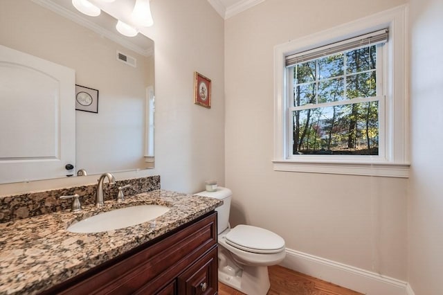 bathroom with hardwood / wood-style floors, vanity, a healthy amount of sunlight, and toilet