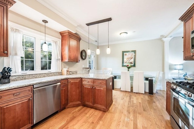 kitchen with kitchen peninsula, hanging light fixtures, appliances with stainless steel finishes, and light hardwood / wood-style flooring