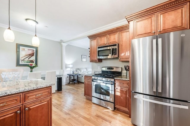 kitchen with light stone countertops, ornamental molding, appliances with stainless steel finishes, decorative light fixtures, and light hardwood / wood-style floors