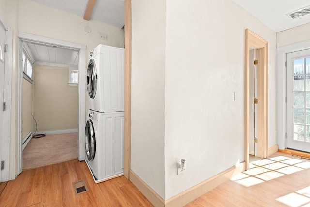 laundry room with laundry area, visible vents, light wood-style floors, and stacked washer and clothes dryer