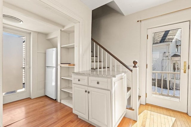 interior space featuring wood finished floors and freestanding refrigerator