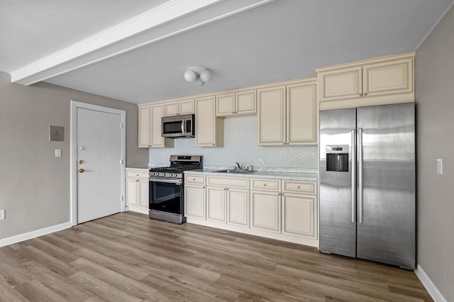 100 Magnolia Ave Unit 26, Lynn, MA 01904 - kitchen with appliances with stainless steel finishes, cream cabinets, light wood-style flooring, and light countertops
