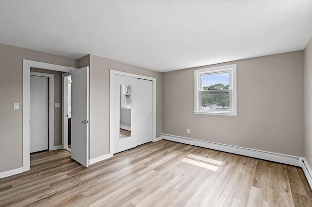 100 Magnolia Ave Unit 26, Lynn, MA 01904 - unfurnished bedroom with light wood-style floors, baseboards, a closet, and baseboard heating