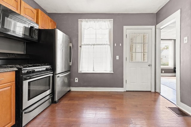 57 Bessom St, Lynn, MA 01902 - kitchen with stainless steel gas range oven, black microwave, wood finished floors, and brown cabinets