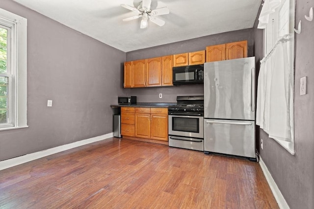 57 Bessom St, Lynn, MA 01902 - kitchen featuring stainless steel appliances, wood finished floors, a ceiling fan, dark countertops, and lofted ceiling