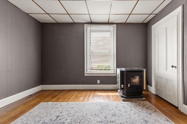 57 Bessom St, Lynn, MA 01902 - unfurnished bedroom featuring a wood stove, wood finished floors, and a paneled ceiling