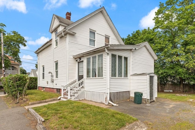 57 Bessom St, Lynn, MA 01902 - view of front of house featuring a chimney, entry steps, and a front lawn