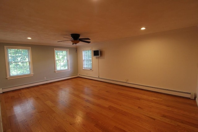 empty room with recessed lighting, a baseboard radiator, a ceiling fan, and wood finished floors