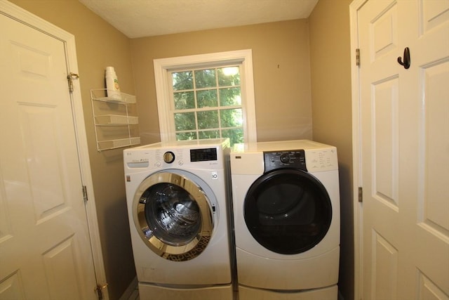 clothes washing area with independent washer and dryer and laundry area