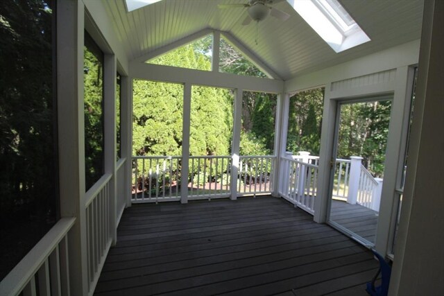 unfurnished sunroom with ceiling fan and lofted ceiling with skylight