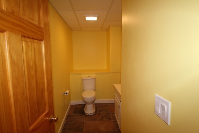 bathroom featuring vanity, toilet, a paneled ceiling, and tile patterned flooring