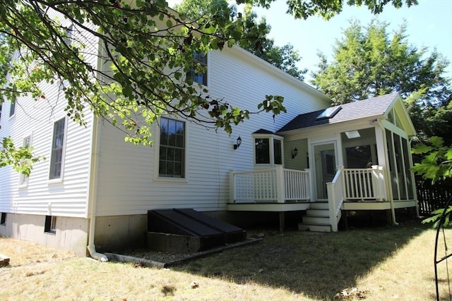 rear view of property with a deck and a lawn
