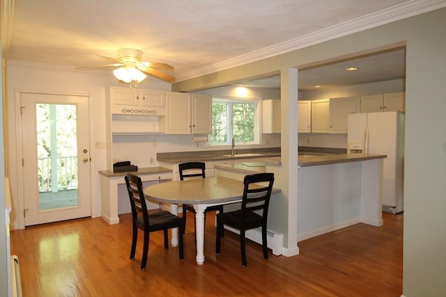 dining space featuring light wood finished floors, crown molding, and ceiling fan
