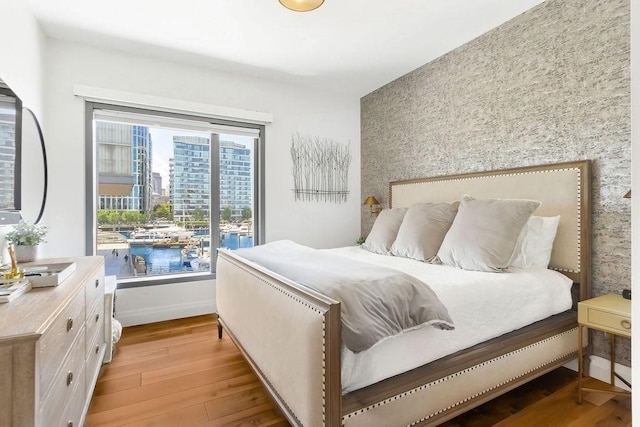 300 Blvd 3I, Boston, MA 02210 - bedroom featuring an accent wall, wallpapered walls, light wood-style floors, and baseboards