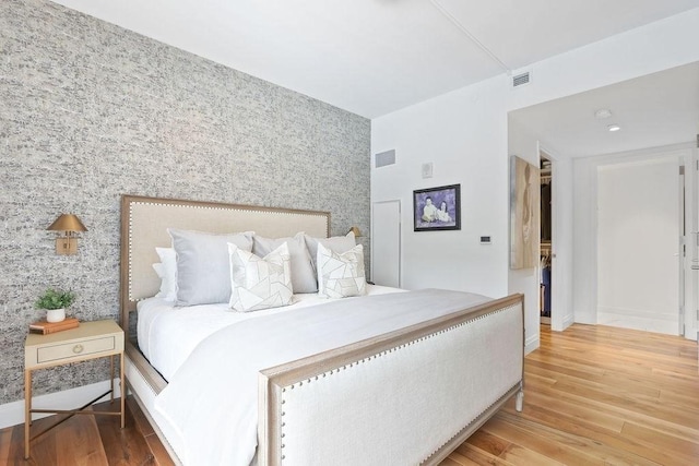 300 Blvd 3I, Boston, MA 02210 - bedroom featuring wallpapered walls, an accent wall, wood finished floors, and baseboards