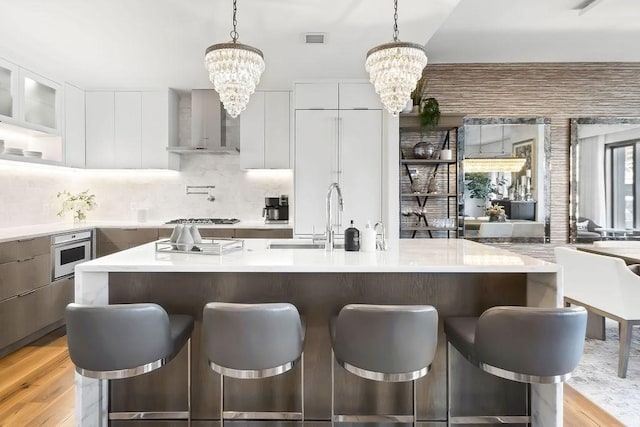 300 Blvd 3I, Boston, MA 02210 - kitchen featuring modern cabinets, a chandelier, wall chimney exhaust hood, and a sink