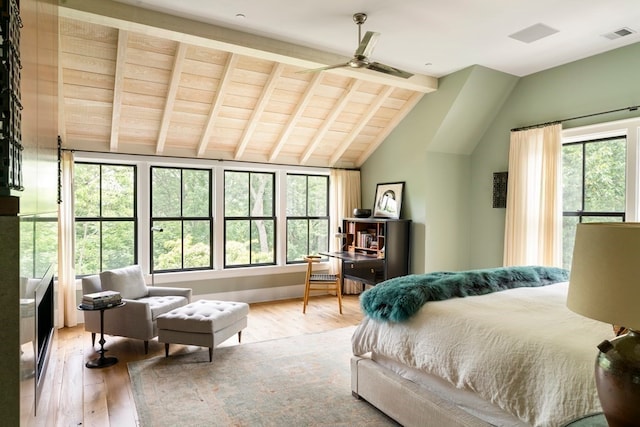 bedroom featuring multiple windows, lofted ceiling with beams, and wood-type flooring