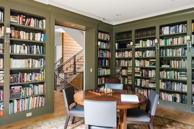 living area with built in shelves and wood-type flooring