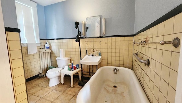 132 Institute Rd, Worcester, MA 01602 - bathroom with a bath, tile patterned flooring, tile walls, radiator, and wainscoting