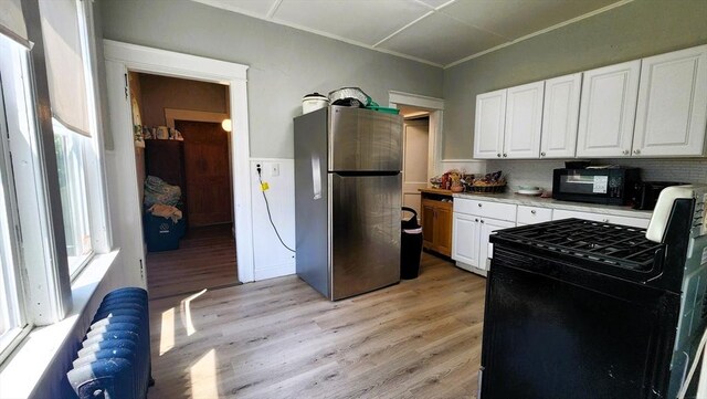 132 Institute Rd, Worcester, MA 01602 - kitchen with black appliances, plenty of natural light, white cabinetry, light wood finished floors, and ornamental molding