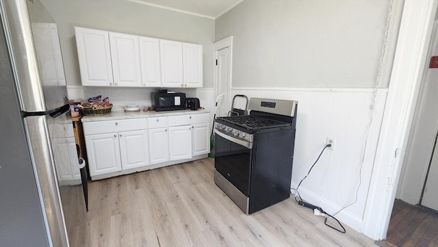 132 Institute Rd, Worcester, MA 01602 - kitchen with appliances with stainless steel finishes, light wood-style flooring, white cabinetry, light countertops, and wainscoting