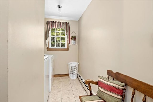 washroom with a baseboard radiator, washer and clothes dryer, baseboards, and light tile patterned floors