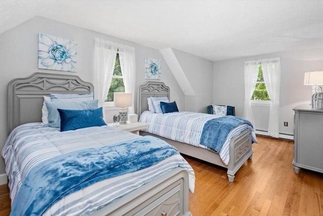 bedroom with light wood-type flooring and a baseboard radiator