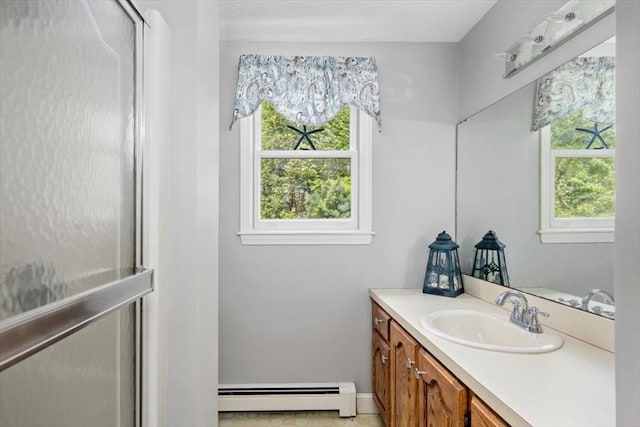 bathroom with baseboard heating, plenty of natural light, vanity, and baseboards