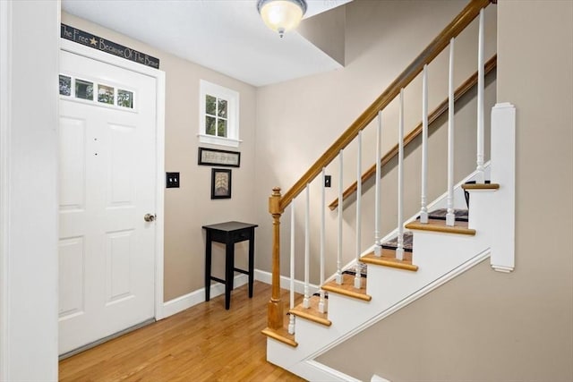 entrance foyer featuring stairs, wood finished floors, and baseboards