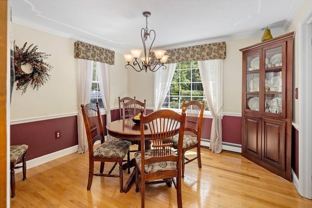 dining room featuring crown molding, a chandelier, light wood-type flooring, a baseboard heating unit, and baseboards