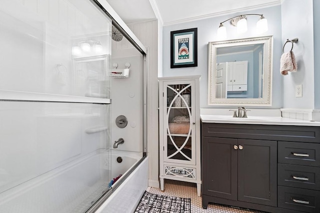 full bath featuring combined bath / shower with glass door, ornamental molding, and vanity