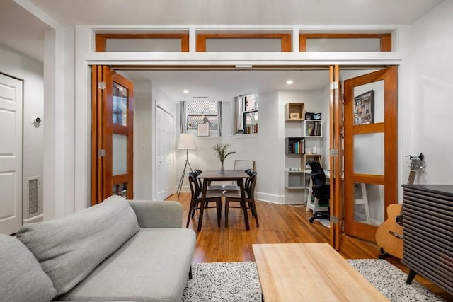 living room with baseboards, recessed lighting, visible vents, and light wood-style floors