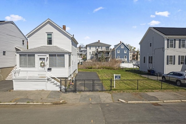 view of front of property with a gate, a residential view, a chimney, asphalt driveway, and roof with shingles