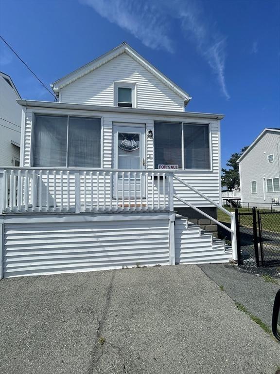 view of front of home featuring a sunroom, fence, and stairway